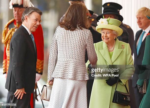 Queen Elizabeth II greets Maria Clemencia de Santos as her husband Colombia's President Juan Manuel Santos looks on at a ceremonial welcome for...