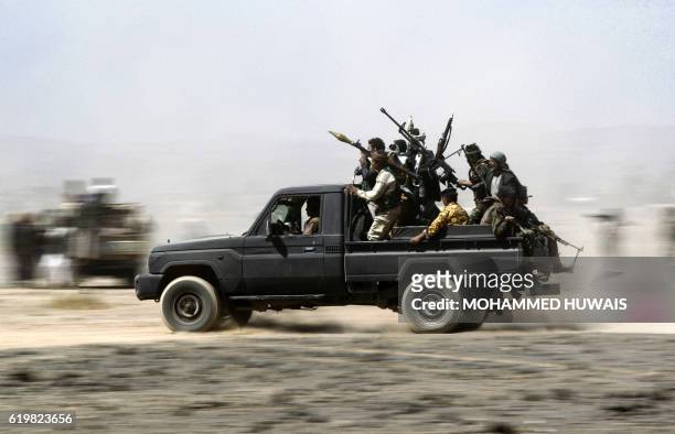 Armed Yemeni tribesmen loyal to the Shiite Huthi rebels sit in the back of an armed vehicle during a gathering to mobilise more fighters into several...