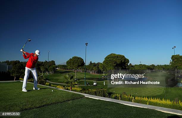 Li Haotong of China hits a shot from the 16th tee which is ontop of a villa during a practise day for the Turkish Airlines Open at the Regnum Carya...
