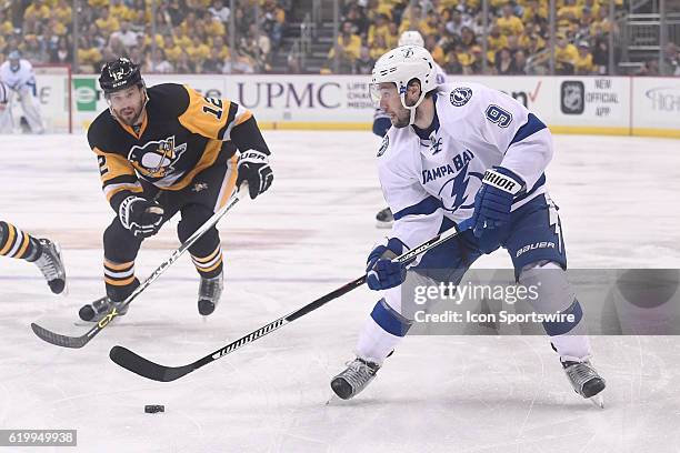 Tampa Bay Lightning center Tyler Johnson skates with the puck as Pittsburgh Penguins defenseman Ben Lovejoy defends during the first period. The...