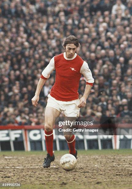 Charlie George of Arsenal in action during a match at Highbury circa 1975, pictured in the back are the letters for the half-time scores.