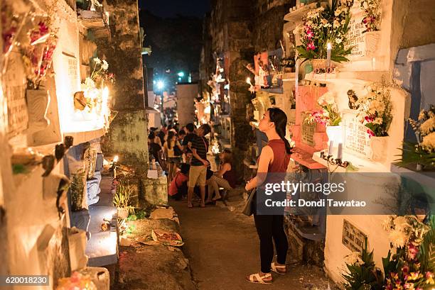 Woman looks at tombstones at a public cemetery on November 1, 2016 in Manila, Philippines. Filipinos flock to cemeteries around the country to visit...