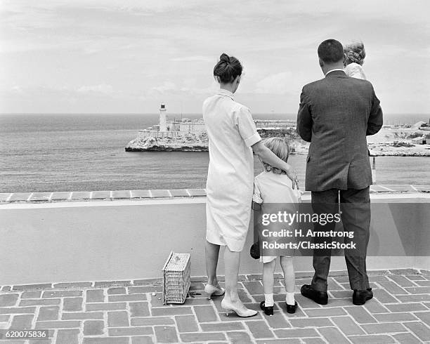 1960s BACK VIEW OF FAMILY LOOKING OVER HAVANA HARBOR WITH MORRO CASTLE IN DISTANCE