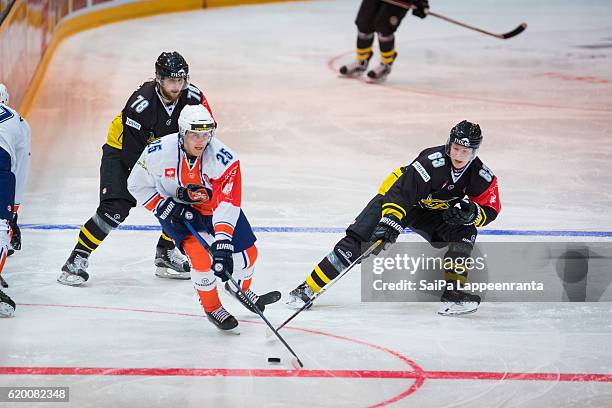 Mikael Kuronen and Eetu Koski of Lappeenranta challenges Philip Holm of Vaxjo during the Champions Hockey League Round of 16 match between SaiPa...