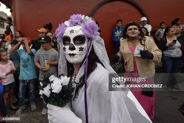 Woman fancy dressed as "Catrina" takes part in the traditional "Convite de fieros" festival, as part of All Saints Day celebrations in Villa Nueva,...