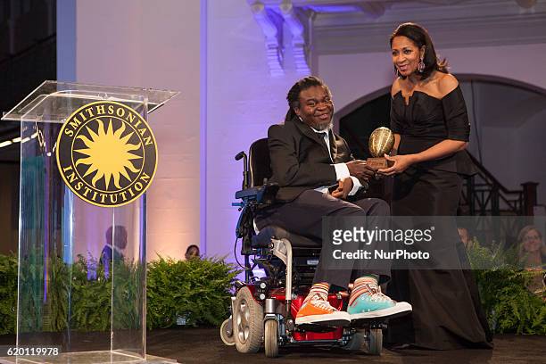 , artist Yinka Shonibare , accepts his African Art Award from Amelia Quist Ogunlesi, at The Smithsonian National Museum of African Art's 1st annual...