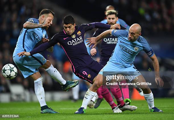 Luis Suarez of Barcelona is tackled by Nicolas Otamendi of Manchester City and Pablo Zabaleta of Manchester City during the UEFA Champions League...