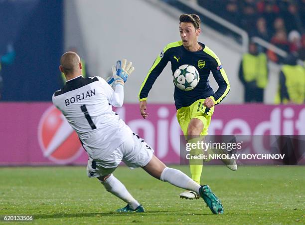 Arsenals German midfielder Mesut Ozil drives the ball before scoring a goal during the UEFA Champions League Group A football match between PFC...