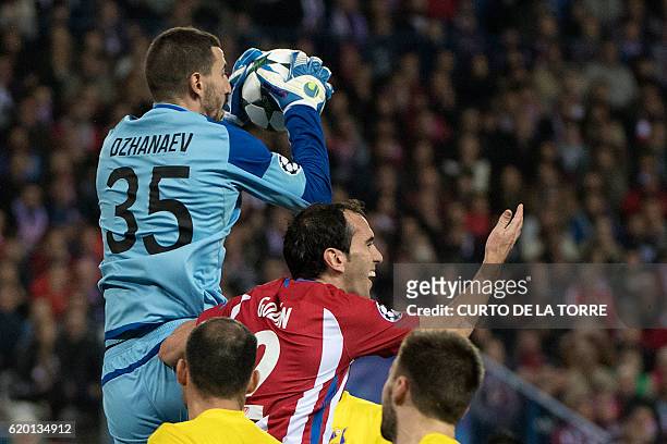 Rostov's goalkeeper Soslan Dzhanaev vies with Atletico Madrid's Uruguayan defender Diego Godin during the UEFA Champions League Group D football...