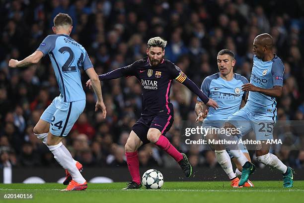Lionel Messi of Barcelona is challenged by Fernandinho of Manchester City during the UEFA Champions League match between Manchester City FC and FC...