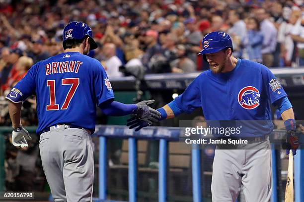 Kris Bryant of the Chicago Cubs celebrates with Ben Zobrist after hitting a solo home run during the first inning against the Cleveland Indians in...