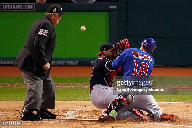 Ben Zobrist of the Chicago Cubs crashes into Roberto Perez of the Cleveland Indians to score a run in the first inning on a double hit by Addison...