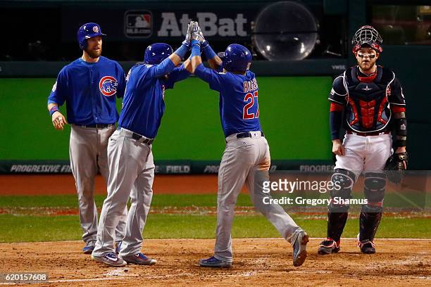 Addison Russell of the Chicago Cubs celebrates with Kyle Schwarber and Ben Zobrist after hitting a grand slam home run during the third inning...