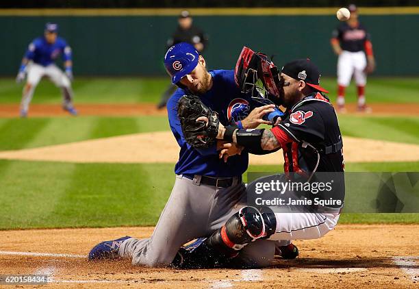 Ben Zobrist of the Chicago Cubs crashes into Roberto Perez of the Cleveland Indians to score a run in the first inning on a double hit by Addison...