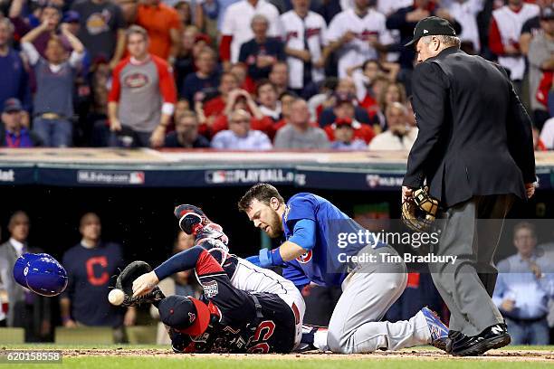 Ben Zobrist of the Chicago Cubs crashes into Roberto Perez of the Cleveland Indians to score a run in the first inning on a double hit by Addison...