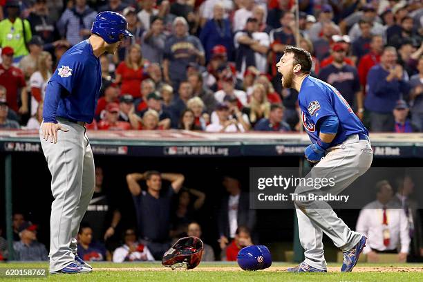 Ben Zobrist of the Chicago Cubs celebrates with teammate Anthony Rizzo after crashing into Roberto Perez of the Cleveland Indians , to score a run in...