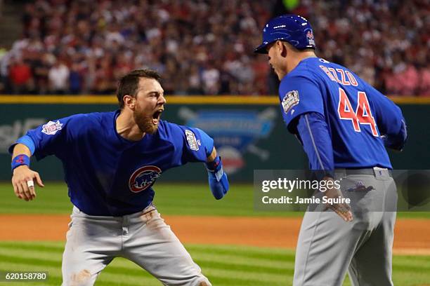 Ben Zobrist of the Chicago Cubs celebrates with teammate Anthony Rizzo after crashing into Roberto Perez of the Cleveland Indians , to score a run in...