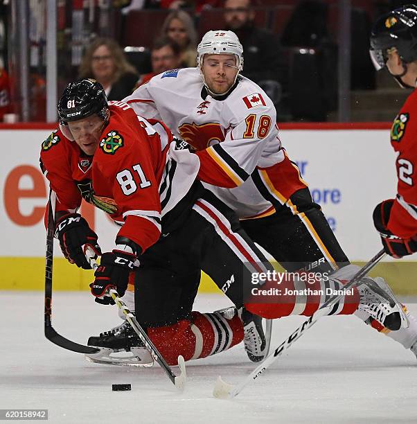 Marian Hossa of the Chicago Blackhawks is knocked to the ice by Matt Stajan of the Calgary Flames at the United Center on November 1, 2016 in...