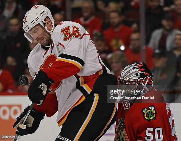 Troy Brouwer of the Calgary Flames is hit by the puck as he screens Corey Crawford of the Chicago Blackhawks at the United Center on November 1, 2016...