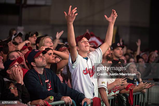 Fan react as the Cleveland Indians give up three runs in the the first inning as they watch on a big screen outside of Progressive Field during game...