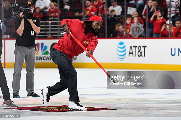 Charles "Peanut" Tillman, former NFL cornerback, shoots the puck in between periods of the game between the Chicago Blackhawks and the Calgary Flames...
