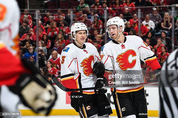 Jyrki Jokipakka and Dougie Hamilton of the Calgary Flames talk in the third period against the Chicago Blackhawks at the United Center on November 1,...