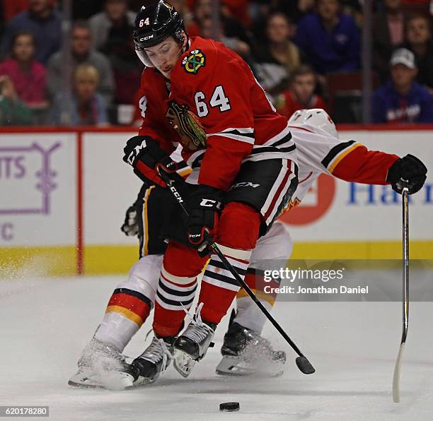 Tyler Motte of the Chicago Blackhawks gets tangled up with TJ Brodie of the Calgary Flames as he moves to score a third period goal at the United...