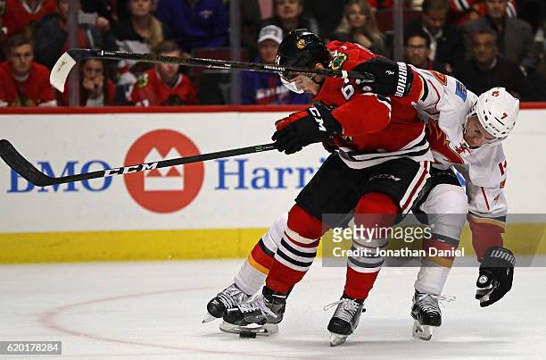 Tyler Motte of the Chicago Blackhawks gets tangled up with TJ Brodie of the Calgary Flames as he moves to score a third period goal at the United...