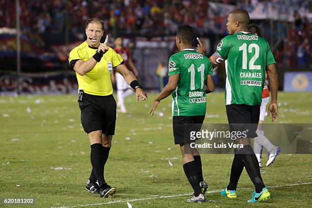 Referee Nestor Pitana shouts to Andres Ibarguen and Alexis Enriquez of Atletico Nacional during a first leg match between Cerro Porteño and Atletico...