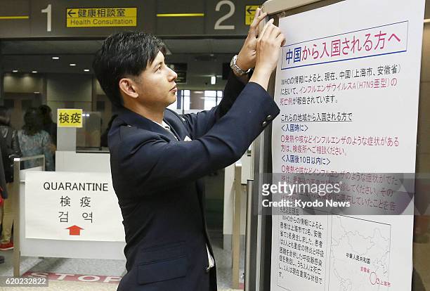 Japan - An official of the quarantine station at Narita airport near Tokyo displays a poster on April 3 warning people arriving from China about...