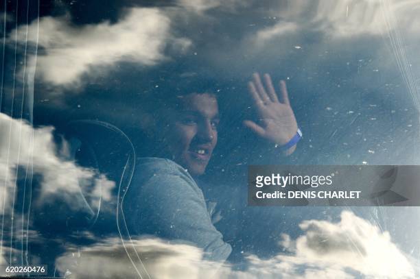 An unaccompanied migrant minor, from the demolished "Jungle" migrant camp in Calais, waves from a bus travelling to reception centres around France...