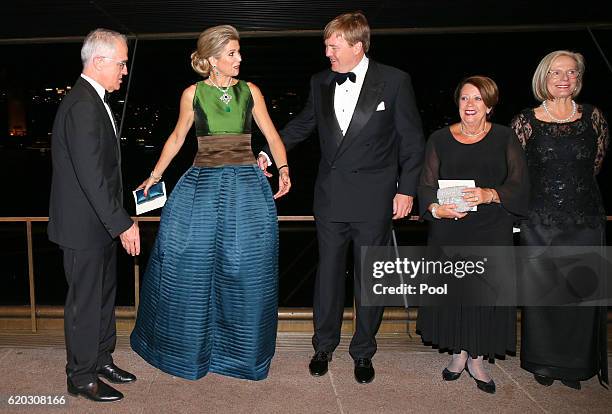 Queen Maxima of the Netherlands gestures to her husband King Willem-Alexander as they arrange positions for a group photograph as Australian Prime...