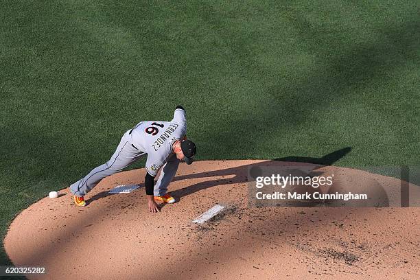 National League All-Star Jose Fernandez of the Miami Marlins leans down and grabs a handful of dirt off the pitchers mound while pitching during the...