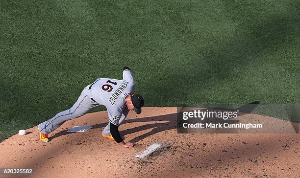 National League All-Star Jose Fernandez of the Miami Marlins leans down and grabs a handful of dirt off the pitchers mound while pitching during the...