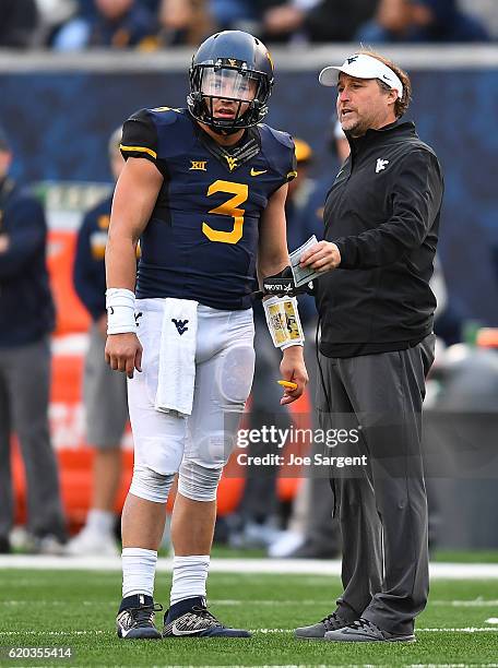 Head coach Dana Holgorsen of the West Virginia Mountaineers talks with Skyler Howard during the game against the TCU Horned Frogs at Mountaineer...