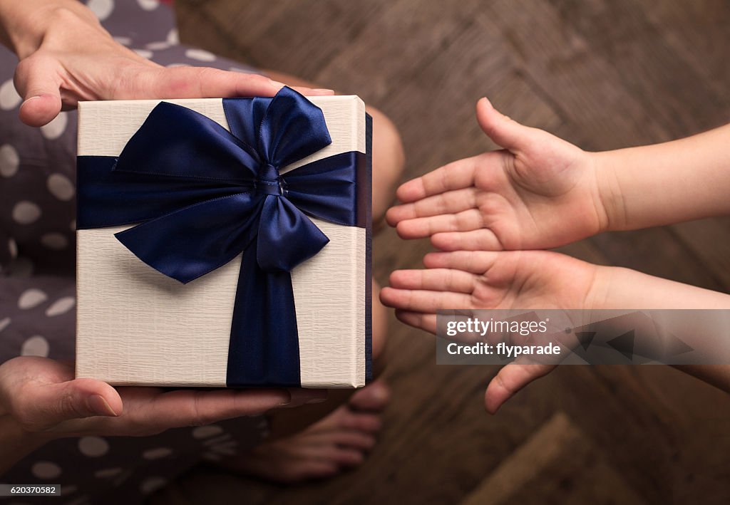 Mother giving a big gift boxes to her kid