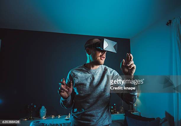 mann schaut vr-film mit virtual-reality-brille headset - mann headset stock-fotos und bilder
