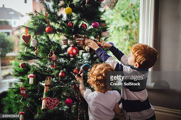 helping mum with the tree - decoration stock pictures, royalty-free photos & images