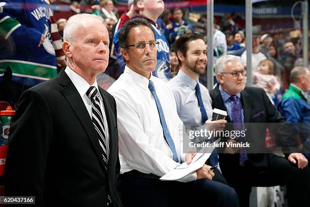 Assistant coach Doug Jarvis, assistant coach Doug Lidster, video coach Ben Cooper and assistant coach Perry Pearn of the Vancouver Canucks look on...