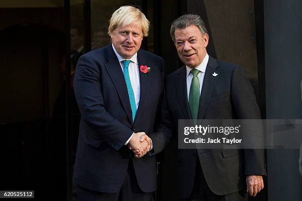 British Foreign Secretary Boris Johnson shakes hands with Colombian President Juan Manuel Santos as they visit the Churchill War Rooms on November 2,...
