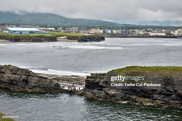 people swimming in the ocean at bundoran of donegal county in ireland - bundoran county donegal stock pictures, royalty-free photos & images