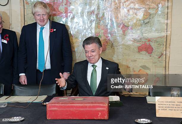 British Foreign Secretary Boris Johnson looks on as Colombia's President Juan Manuel Santos sits in the chair of former British Prime Minister...