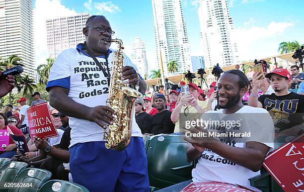 Clyde McPhatter Jr. Cheers Dale Raines as he plays the saxophone for the crowd during a campaign rally for Donald Trump at Bayfront Park Amphitheater...