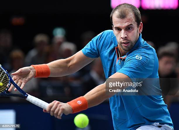 Gilles Muller of Luxembourg plays a backhand during the Men's second round match against Novak Djokovic of Serbia on day three of the BNP Paribas...