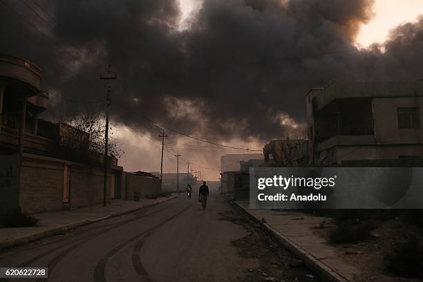 Smoke rises as fire fighters try to extinguish the fire at oil wells, were set on fire by Daesh terrorists as they fled after Al Qayyarah town's...