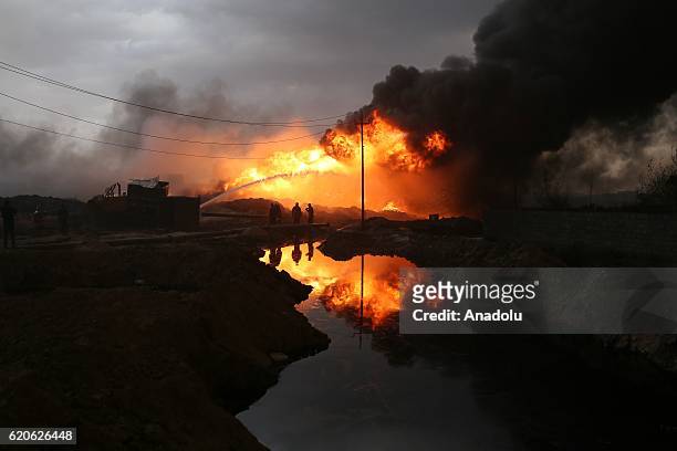 Fire fighters try to extinguish the fire at oil wells, were set on fire by Daesh terrorists as they fled after Al Qayyarah town's cleansing from...