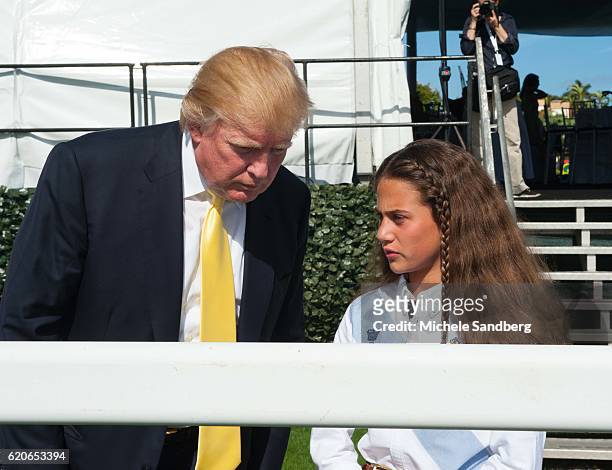 Businessman Donald Trump leans in while speaking with Eva, a friend, at the Trump Invitational Grand Prix at Mar-a-Lago, Palm Beach, Florida, January...