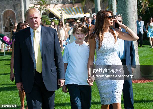 Donald Trump, son Barron, and wife Melania walk on the grounds during the Trump Invitational Grand Prix at Mar-a-Lago, Palm Beach, Florida, January...