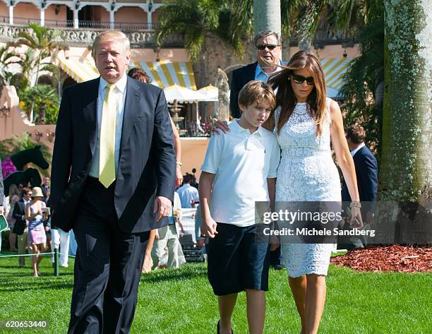 Donald Trump, son Barron, and wife Melania walk on the grounds during the Trump Invitational Grand Prix at Mar-a-Lago, Palm Beach, Florida, January...