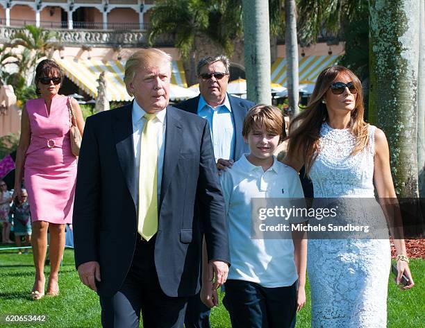 Donald Trump, son Barron, and wife Melania walk on the grounds during the Trump Invitational Grand Prix at Mar-a-Lago, Palm Beach, Florida, January...